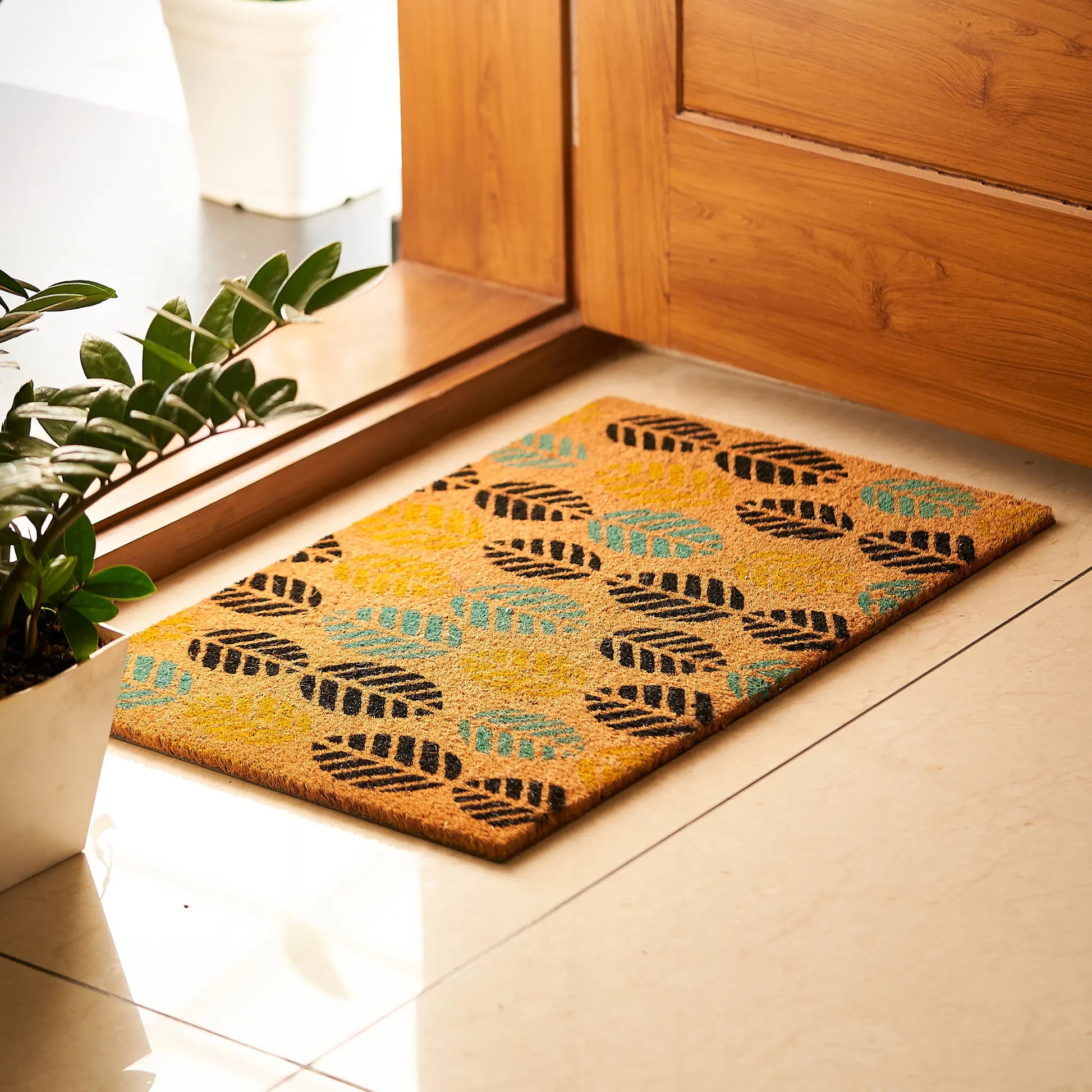Decorative doormat with leaf pattern on a wooden floor