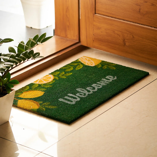 Green doormat with lemon design and 'Welcome' text on a wooden floor.