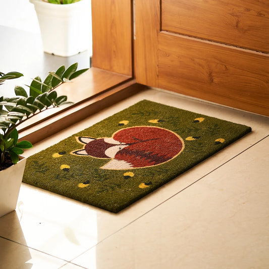 Doormat with a fox design on a tiled floor next to a wooden door.